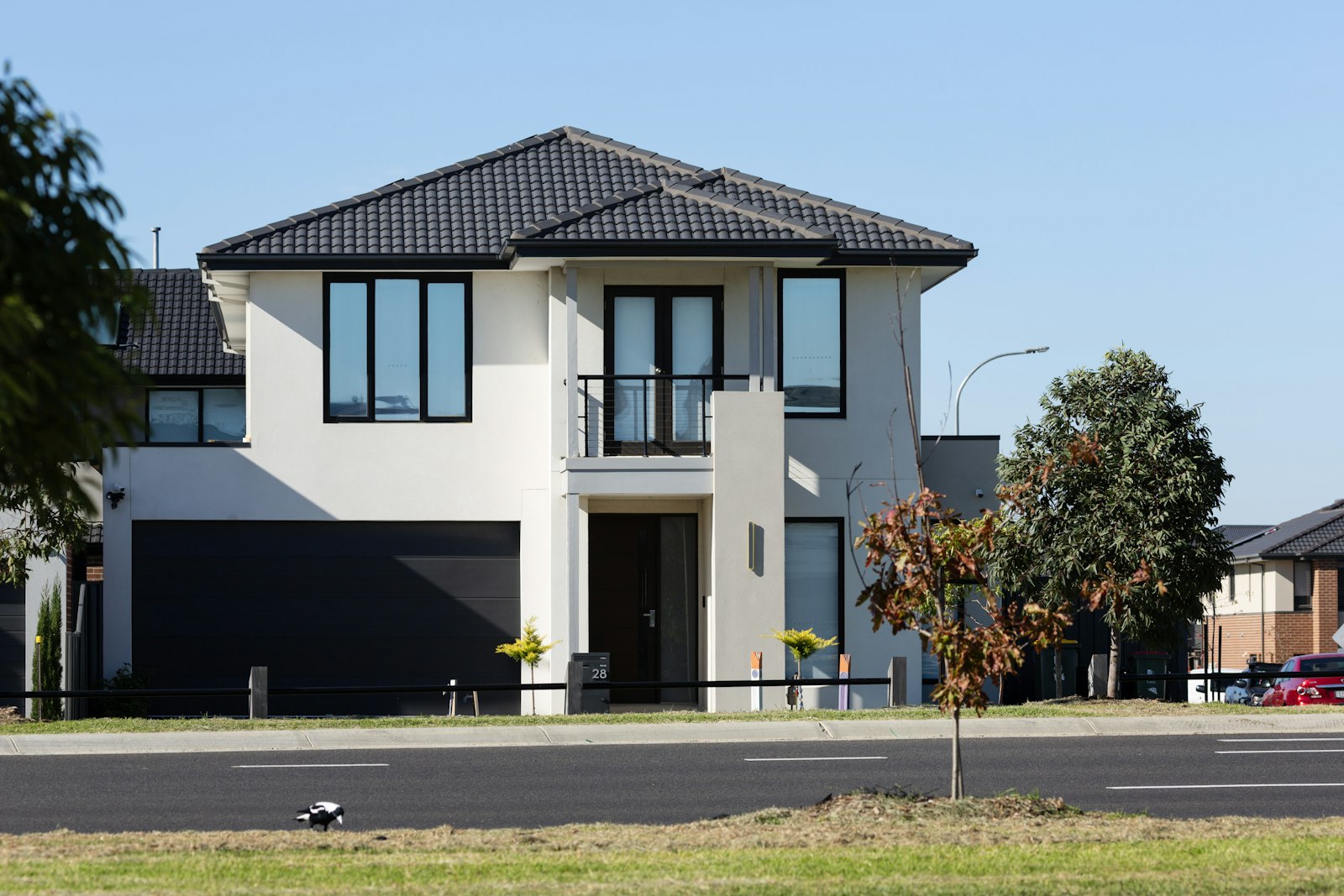 Two-story home with a wide dark garage door