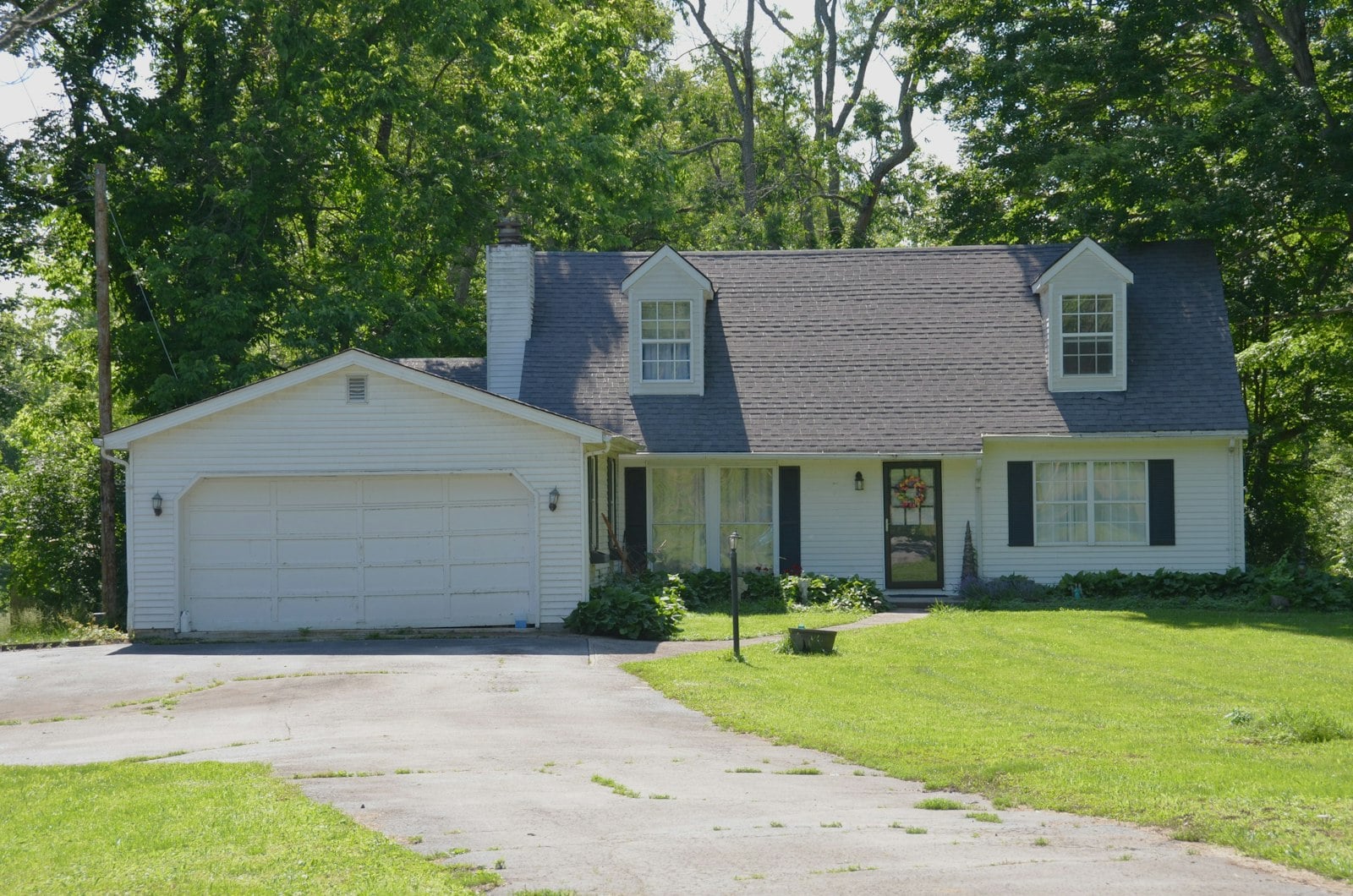 White house with a two-car garage and a long concrete driveway