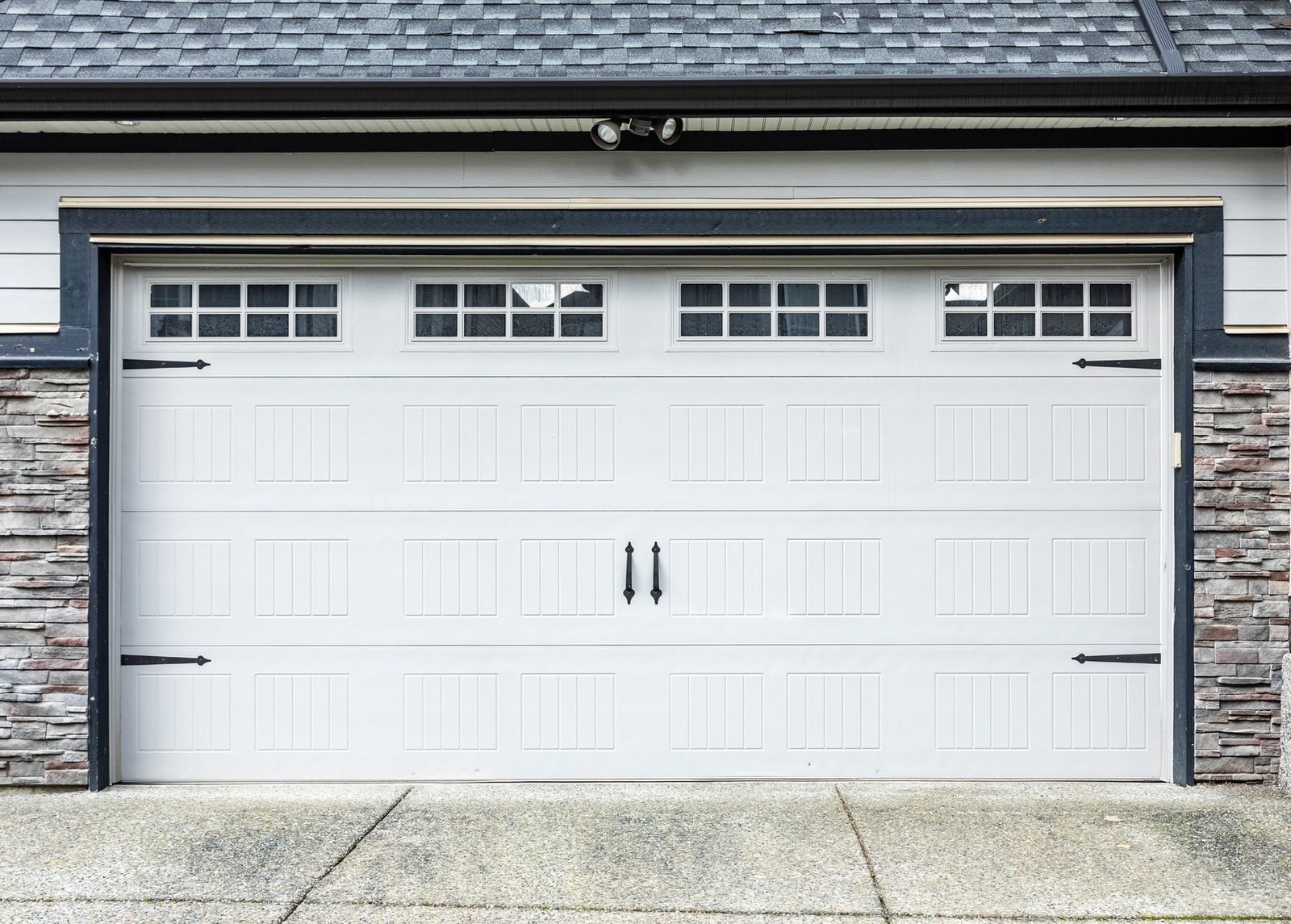 White carriage-style garage door with decorative windows and handles